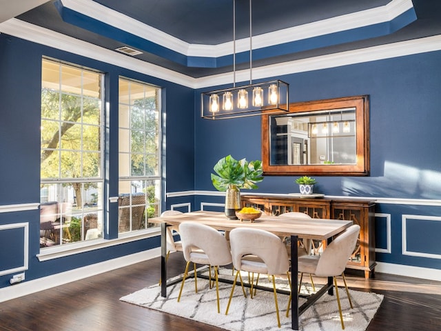 dining space featuring crown molding, a tray ceiling, dark wood-type flooring, and breakfast area