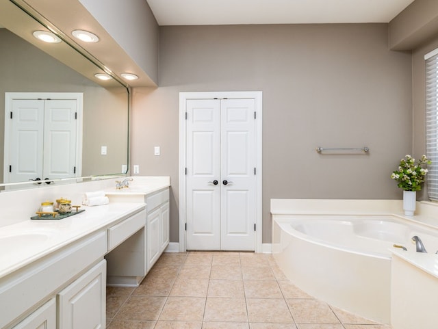 bathroom with tile patterned floors, a tub to relax in, and vanity