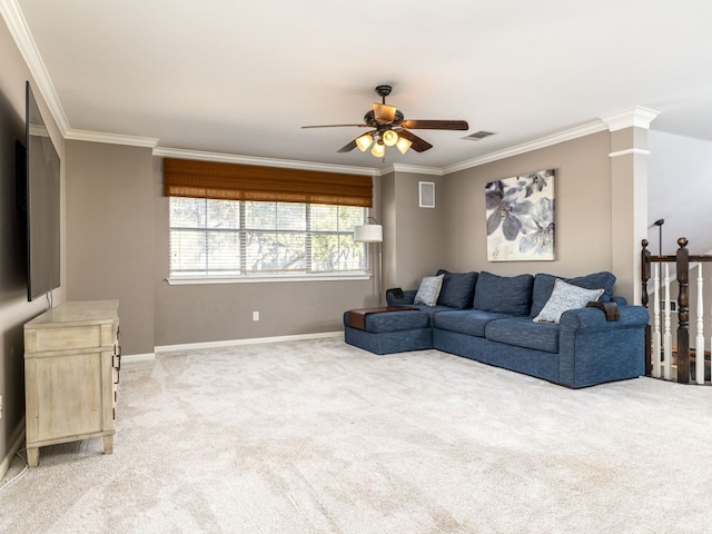 carpeted living room with crown molding, ceiling fan, and decorative columns