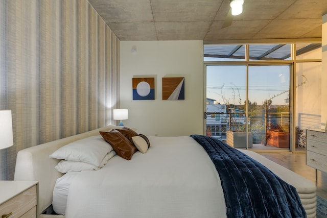 bedroom featuring floor to ceiling windows, access to outside, and hardwood / wood-style floors