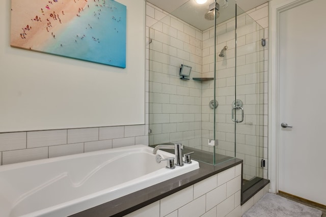 bathroom featuring shower with separate bathtub