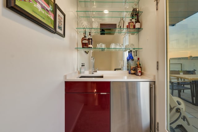 bar with sink and stainless steel fridge