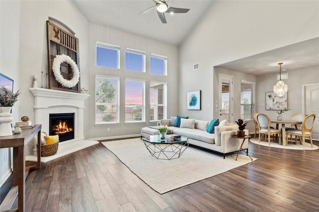 living room featuring plenty of natural light, dark wood-type flooring, high vaulted ceiling, and ceiling fan