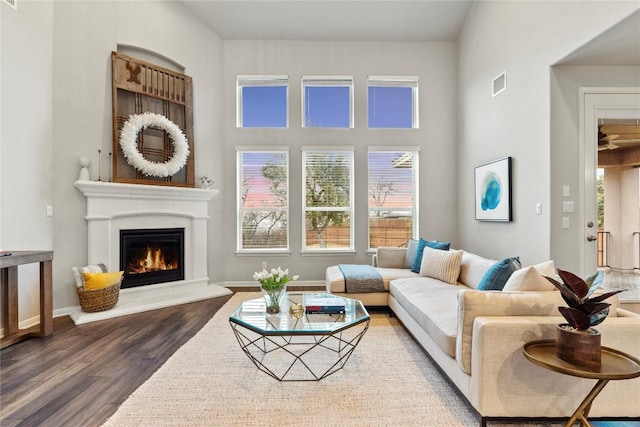 living room with dark hardwood / wood-style flooring and a high ceiling