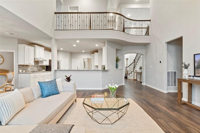 living room featuring dark hardwood / wood-style floors and a high ceiling