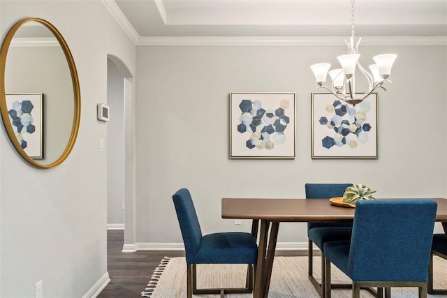 dining room featuring crown molding, dark hardwood / wood-style floors, and an inviting chandelier