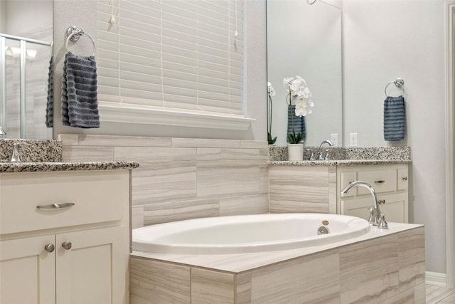 bathroom featuring vanity and tiled bath