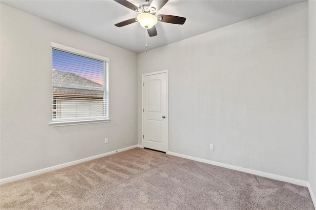 carpeted spare room with ceiling fan