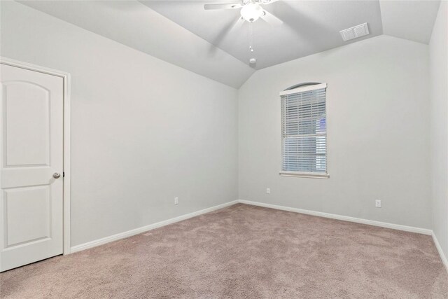 empty room featuring ceiling fan, lofted ceiling, and light carpet