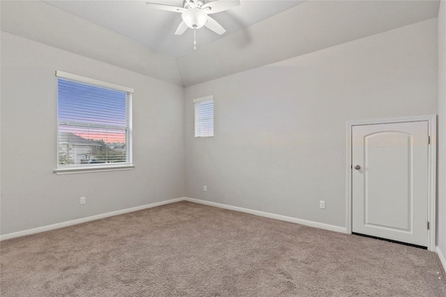 carpeted spare room with vaulted ceiling and ceiling fan