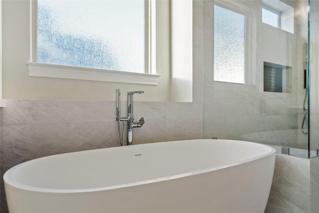 2513 Long Lasso Pass, Leander, TX 78641 - full bathroom with tile walls, a walk in shower, and a soaking tub