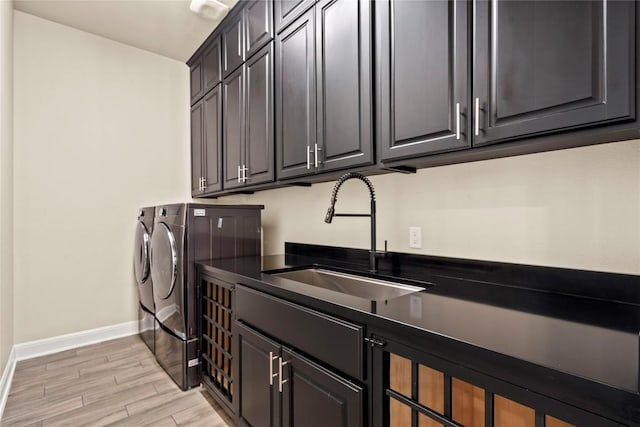 2513 Long Lasso Pass, Leander, TX 78641 - laundry room with washing machine and clothes dryer, cabinet space, and light wood finished floors