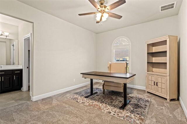 carpeted office space featuring ceiling fan