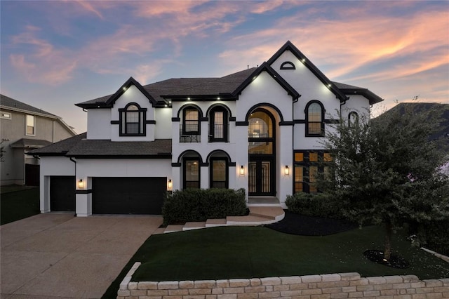 french country inspired facade with a garage and a lawn