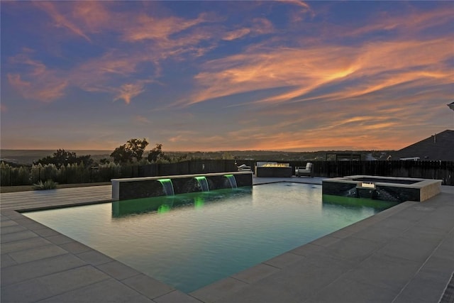 2513 Long Lasso Pass, Leander, TX 78641 - pool at dusk with a pool with connected hot tub, a fenced backyard, and a patio