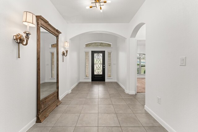 foyer entrance featuring light tile patterned floors and a chandelier