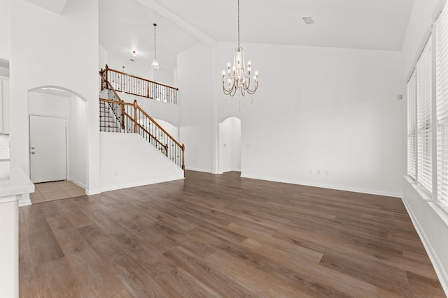 unfurnished living room featuring hardwood / wood-style flooring, a chandelier, high vaulted ceiling, and beamed ceiling