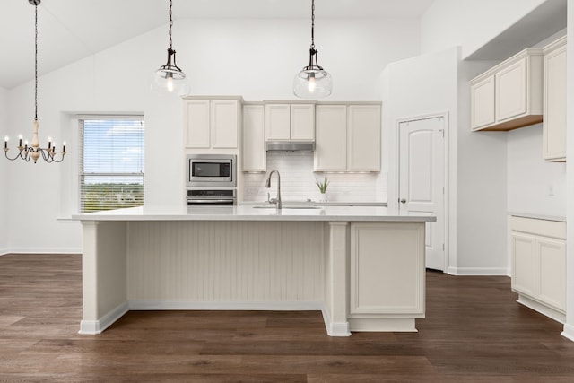 kitchen with a kitchen island with sink, sink, pendant lighting, and appliances with stainless steel finishes