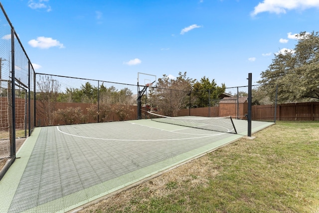 view of sport court featuring a lawn