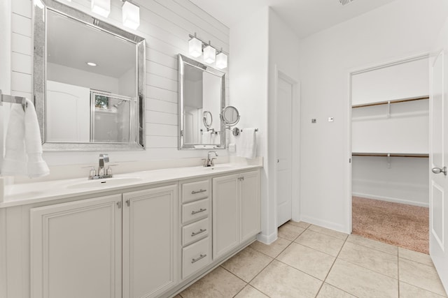 bathroom featuring vanity, a shower with shower door, and tile patterned floors