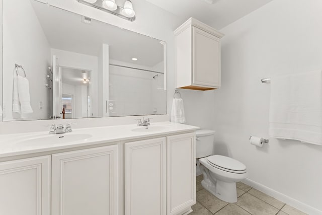 bathroom featuring tile patterned floors, toilet, vanity, and a shower