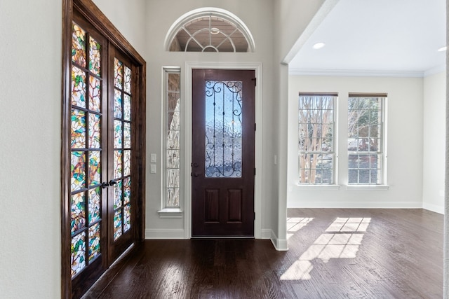 foyer entrance with crown molding, dark wood-type flooring, and french doors