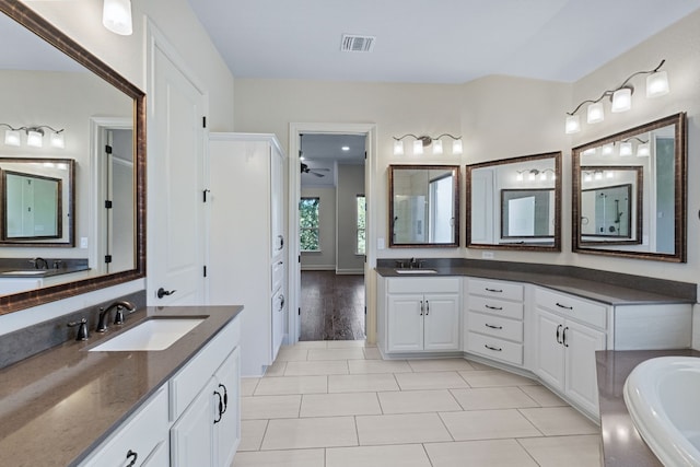 bathroom with vanity, tile patterned flooring, and a washtub