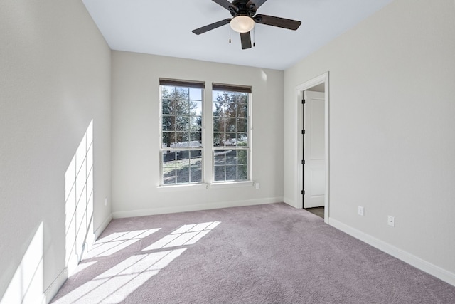 spare room with a wealth of natural light, light colored carpet, and ceiling fan