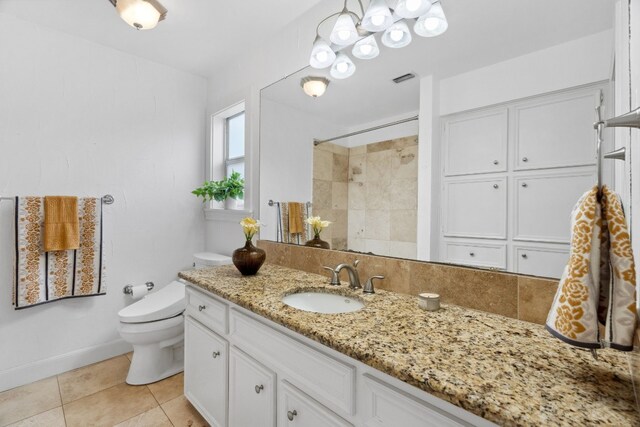 bathroom with vanity, toilet, tile patterned floors, and walk in shower