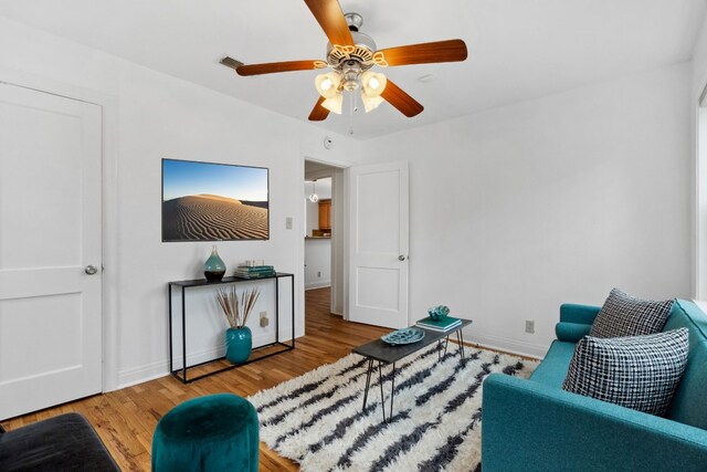 living room featuring wood-type flooring and ceiling fan