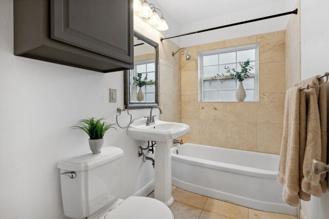 bathroom featuring tile patterned flooring, toilet, and tiled shower / bath