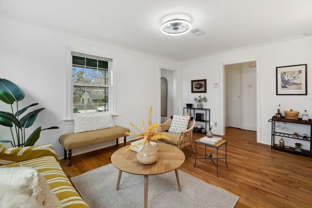 living room featuring wood-type flooring and ornamental molding