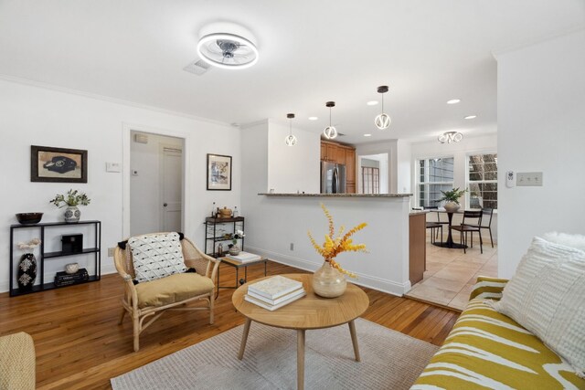 living room with ornamental molding and light wood-type flooring