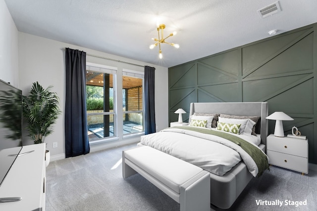 bedroom with access to outside, carpet floors, a textured ceiling, and a notable chandelier