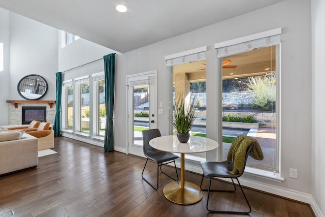 dining room featuring a stone fireplace and dark hardwood / wood-style floors