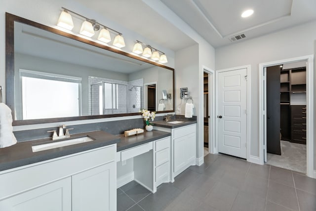 bathroom featuring tile patterned floors, vanity, a tray ceiling, and a shower with door