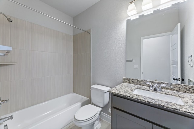 full bathroom featuring vanity, tiled shower / bath, and toilet