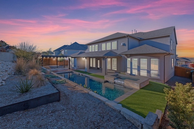 back house at dusk featuring a pool with hot tub and a patio area