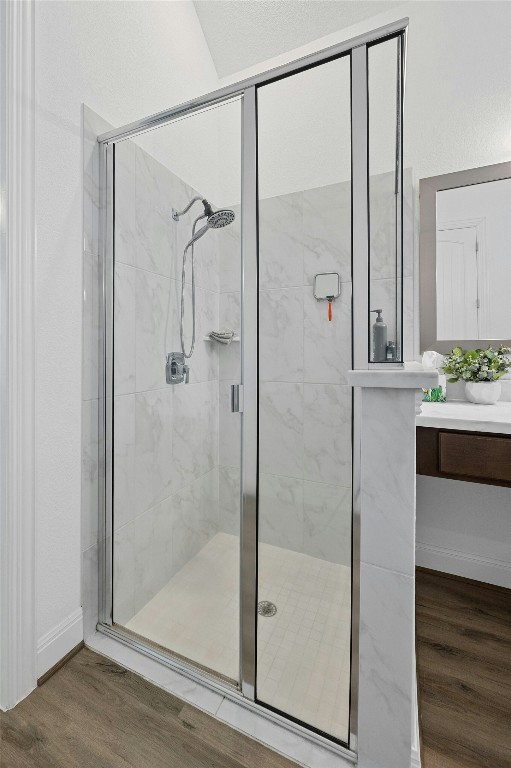 bathroom with vanity, hardwood / wood-style flooring, and walk in shower