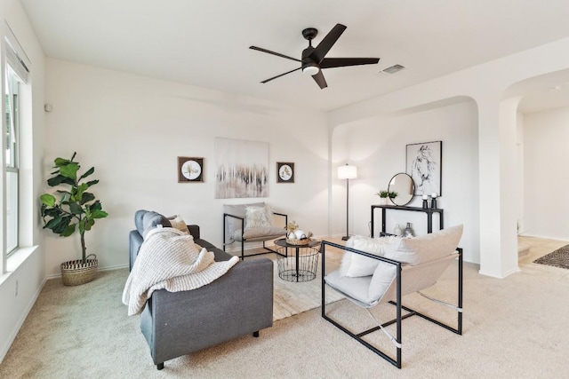 living room with ceiling fan, light carpet, and a wealth of natural light