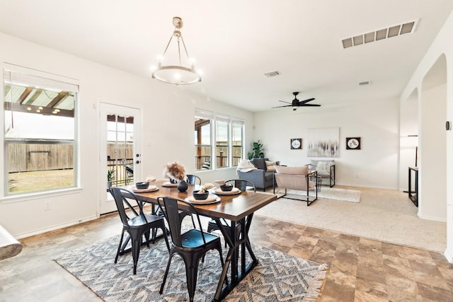 dining room with ceiling fan with notable chandelier