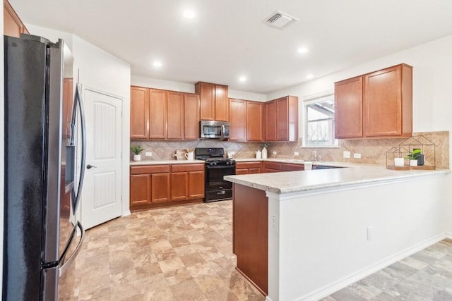 kitchen featuring appliances with stainless steel finishes, sink, backsplash, and kitchen peninsula