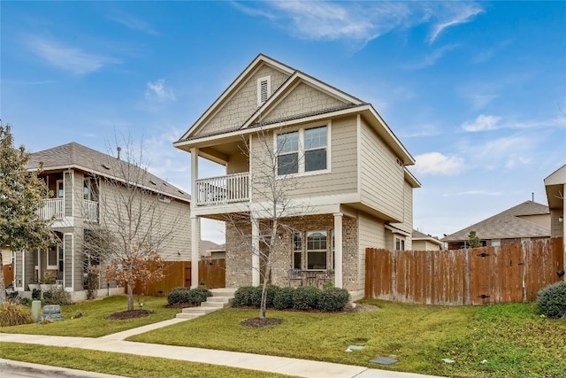 view of front of home featuring a balcony and a front yard