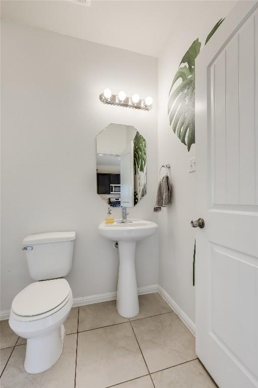 bathroom with toilet and tile patterned flooring