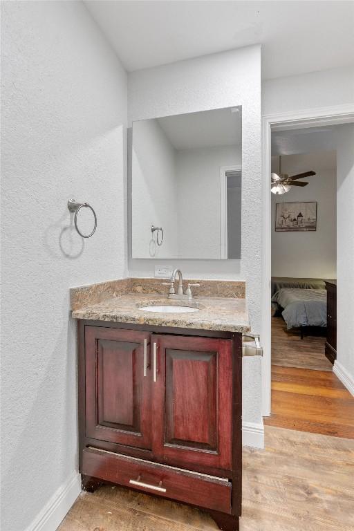 bathroom featuring hardwood / wood-style flooring, ceiling fan, and vanity