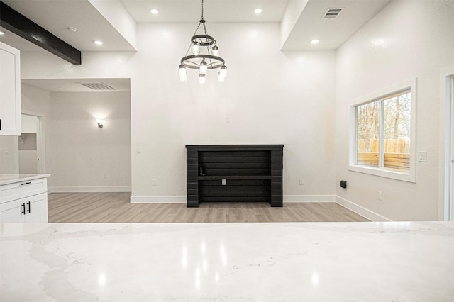 interior space featuring light hardwood / wood-style floors and a high ceiling