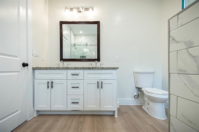 bathroom featuring vanity, wood-type flooring, toilet, and walk in shower