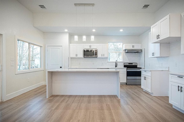 kitchen featuring white cabinetry, appliances with stainless steel finishes, and pendant lighting