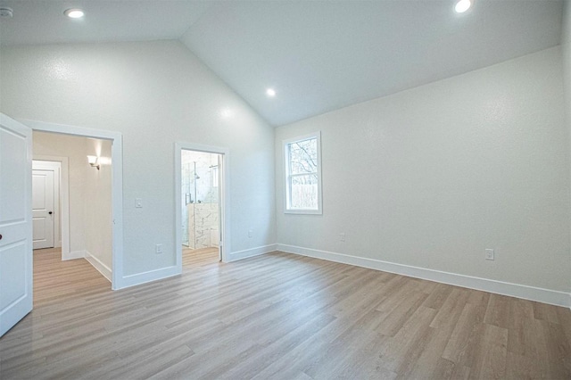 unfurnished bedroom with ensuite bathroom, high vaulted ceiling, and light hardwood / wood-style flooring