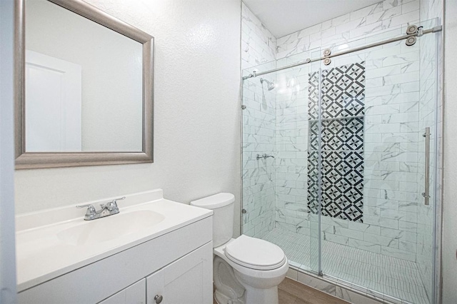 bathroom featuring vanity, walk in shower, and toilet